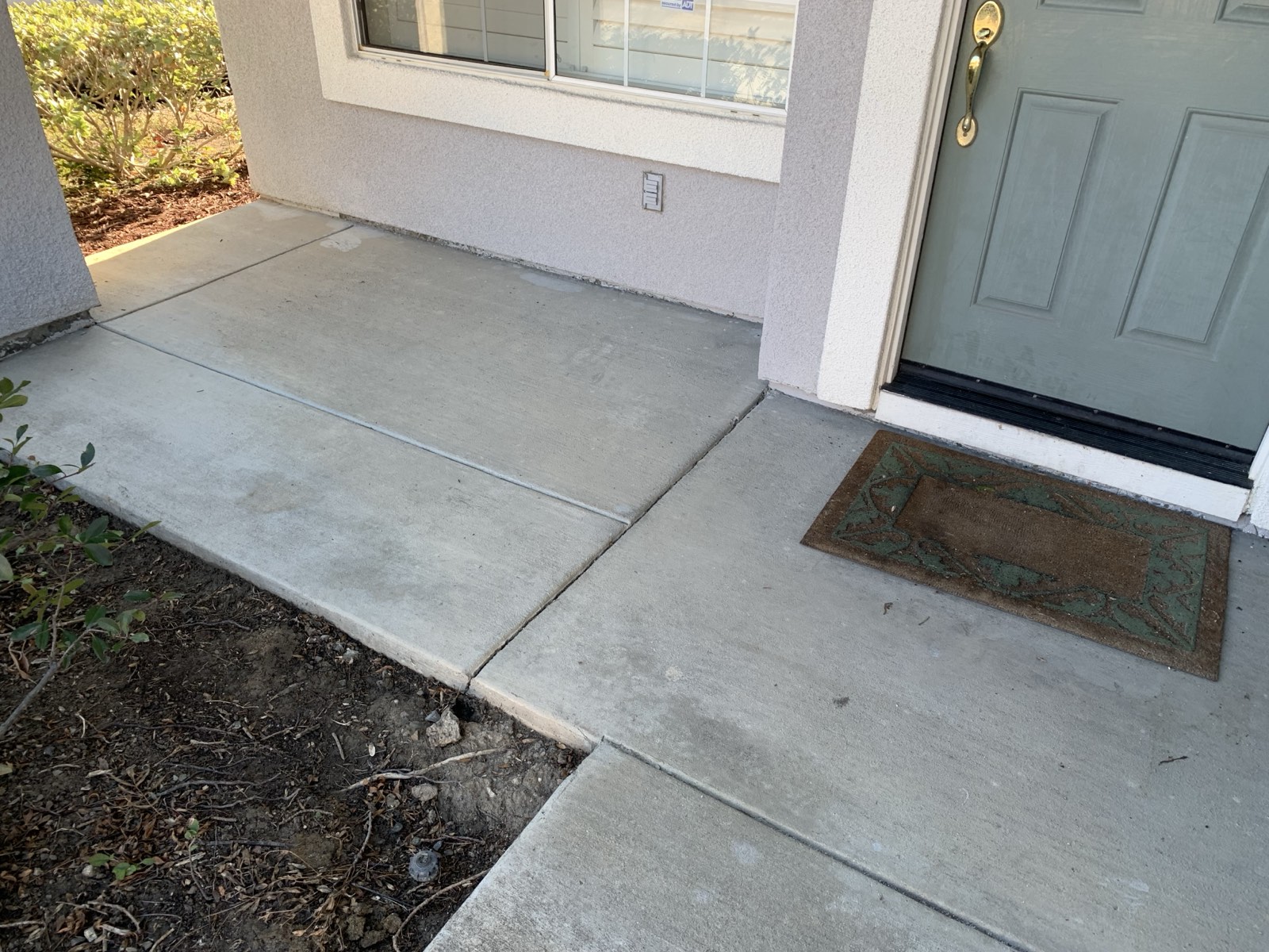 Before — front porch concrete by the door of the Fremont home, dingy with dirt along the edges