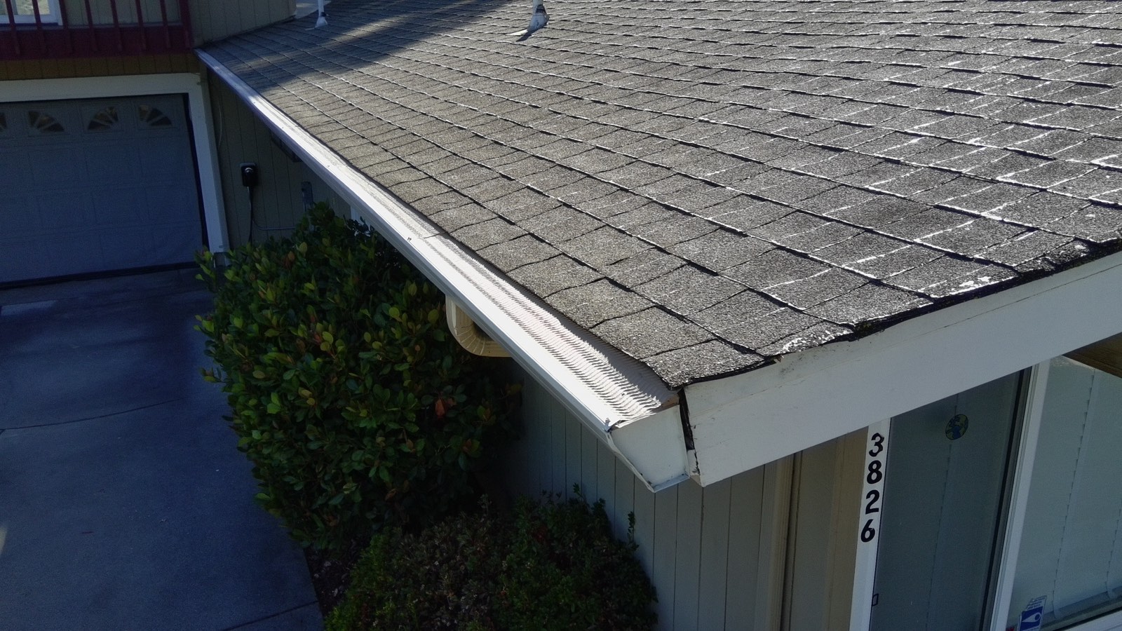 Micro-mesh gutter guards installed across the full eave of a townhome roofline, flush with the shingles