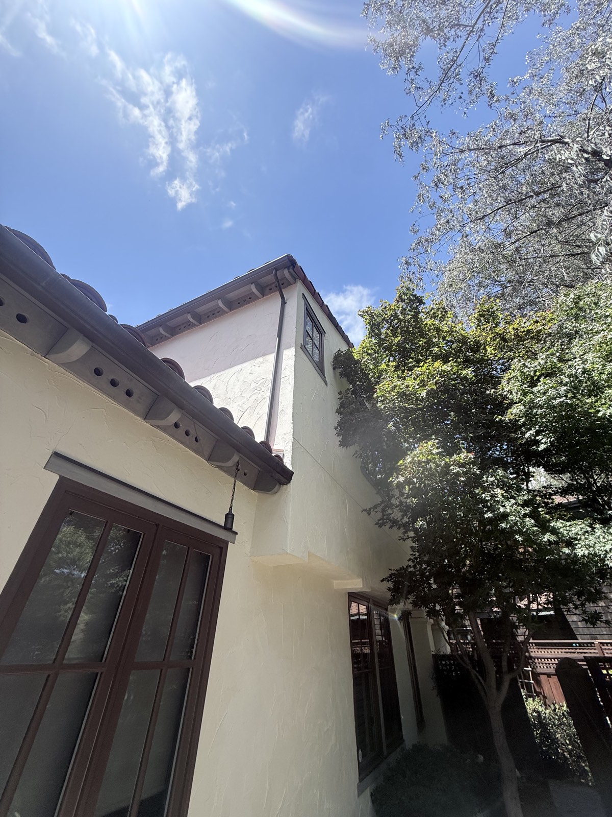 After — eaves, rafter tails, and downspout with rain chain on the Los Gatos home, stucco clean after soft wash