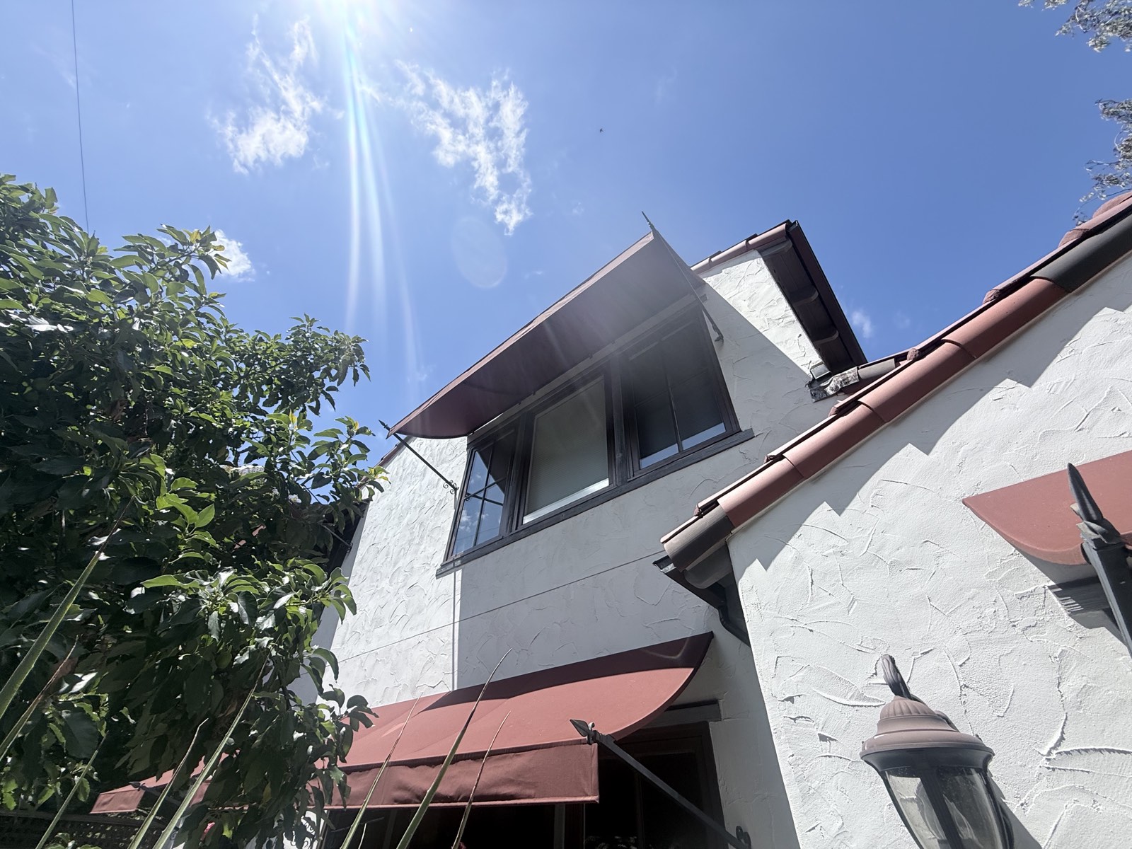 After — upper-story windows and awnings of the Los Gatos home, stucco and lantern washed clean