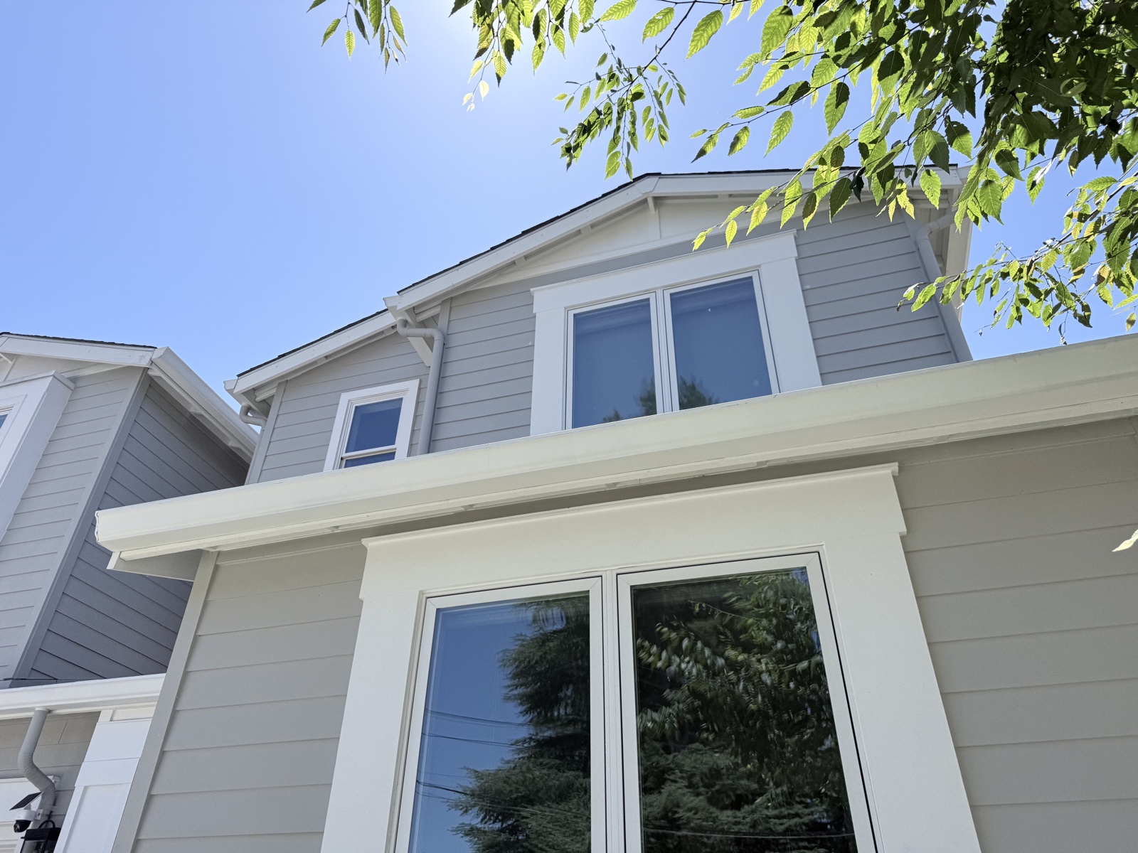 After — upper-story siding, window trim, and gutter line of the Menlo Park home clean after soft wash