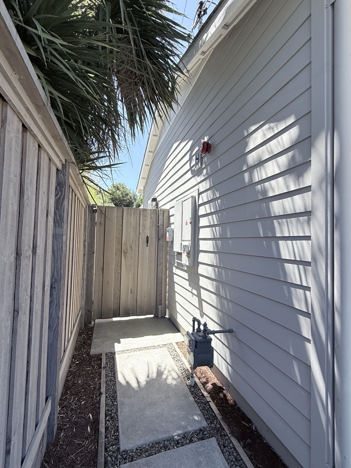 After — side-yard lap siding of the Menlo Park home clean along the fence-line walkway