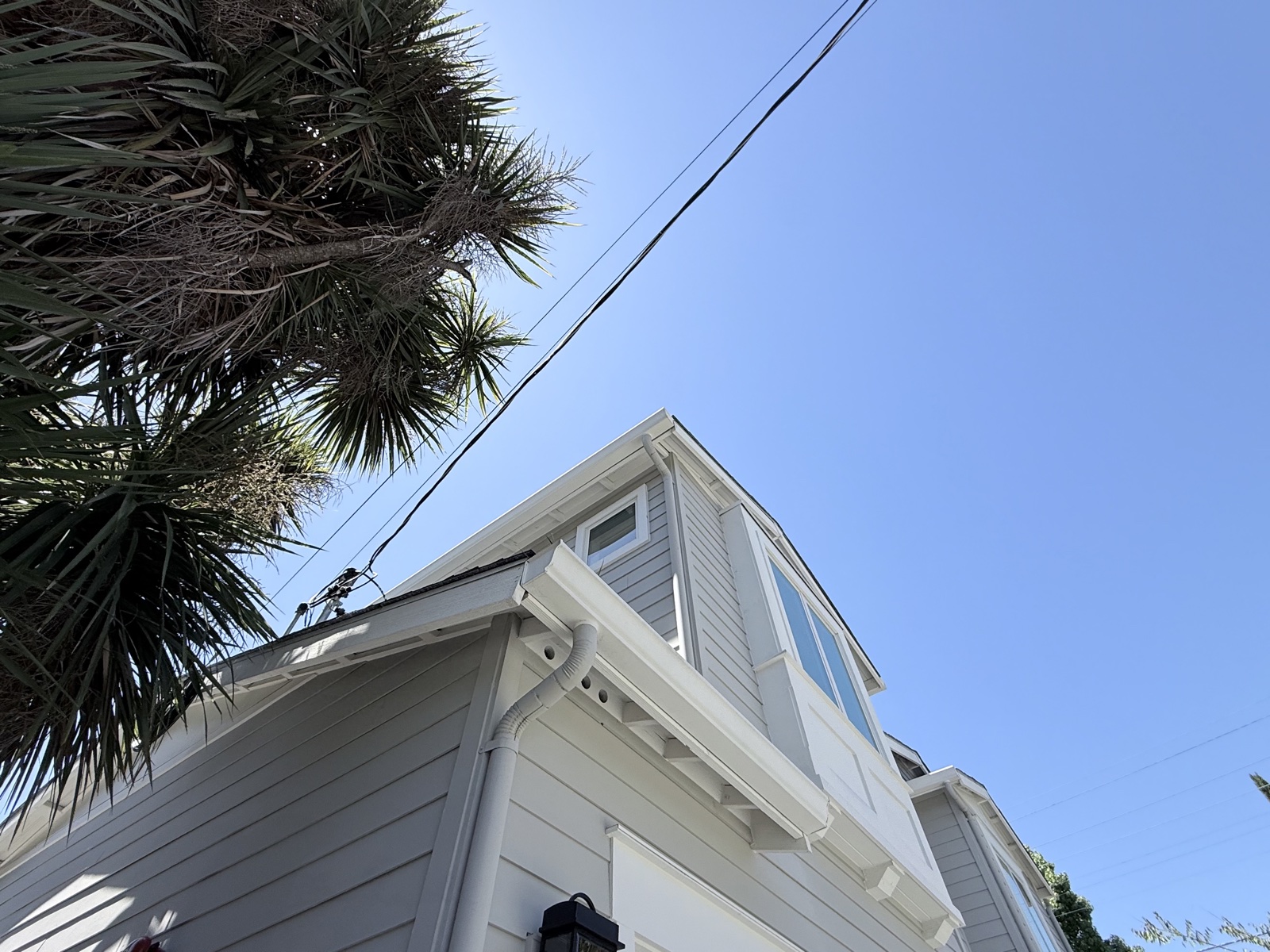After — corner gable, gutter, and downspout of the Menlo Park home clean, seen from the driveway
