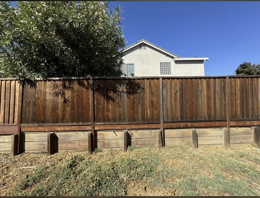 Before — Milpitas wood fence full run showing grey weathering before service