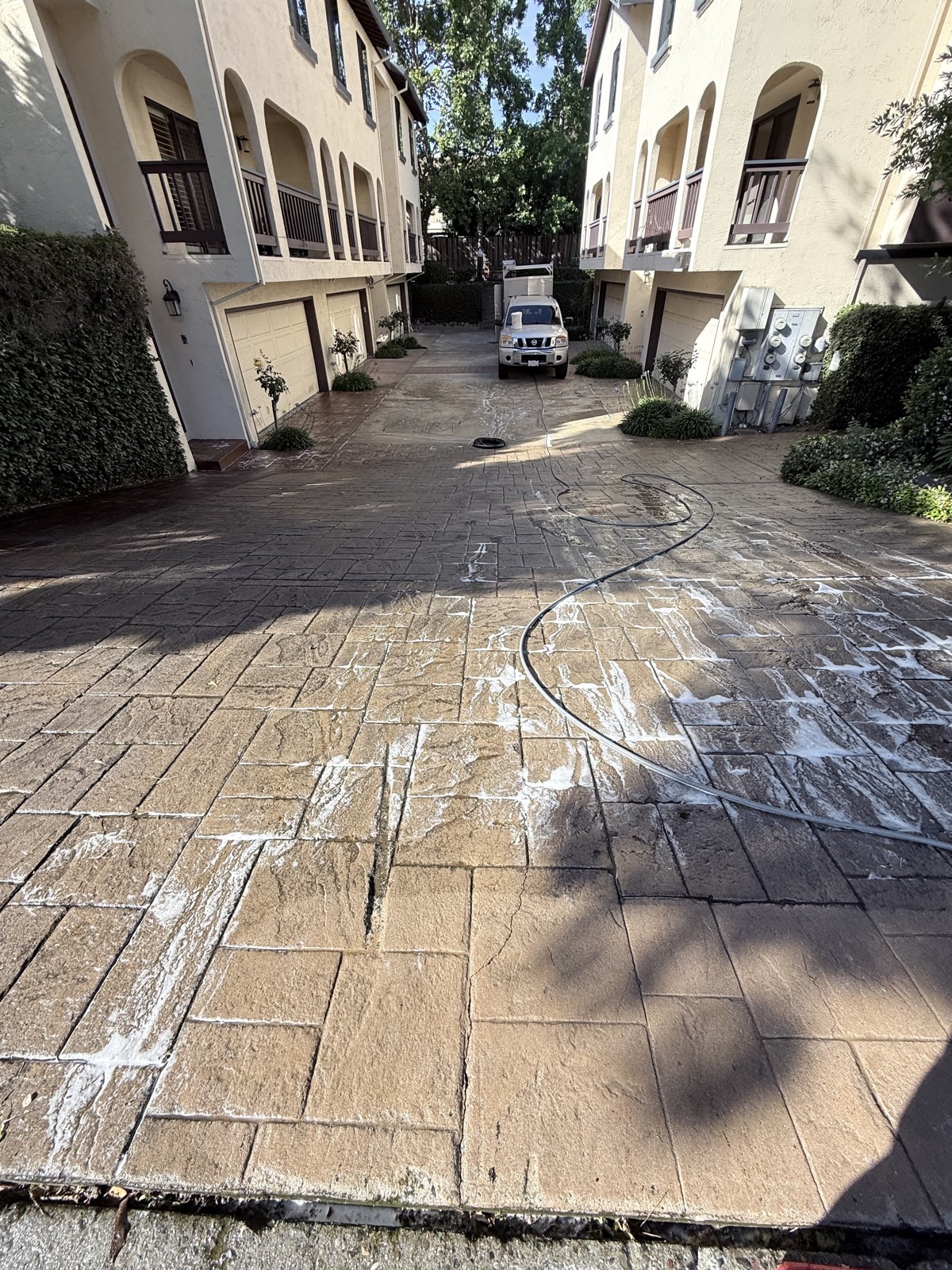 Before — Mountain View HOA drive court between two townhome buildings with grime still covering the paver-stamped concrete